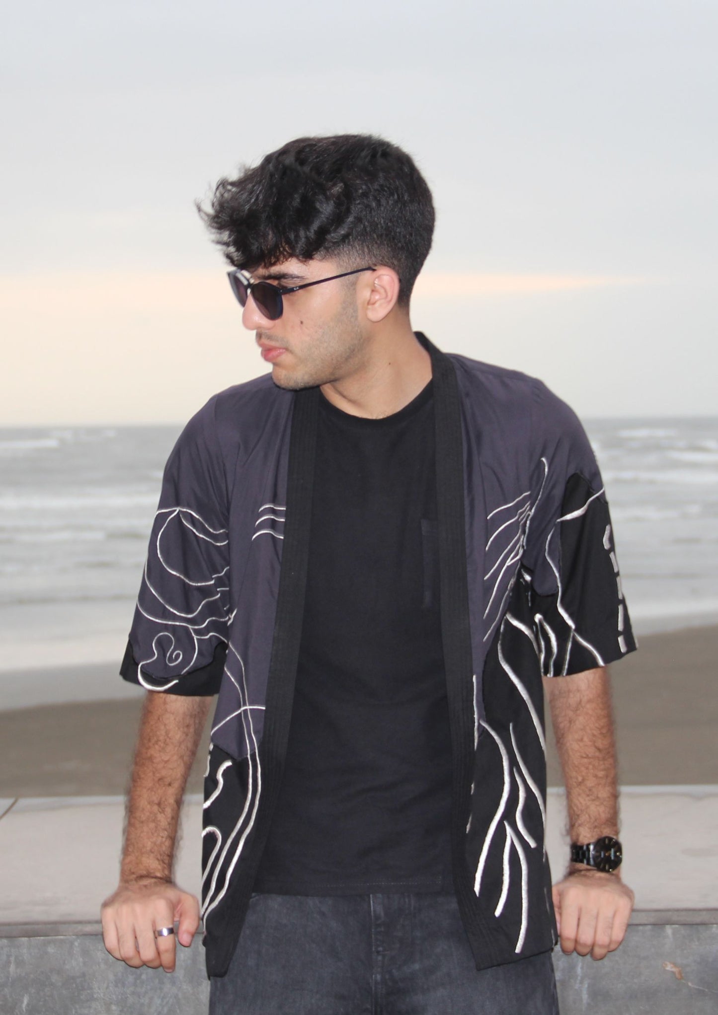 Man wearing Dastaan black, grey, blue and white patterned jacket, kimono, cardigan. Made with Premium Material and Cultural Significance.